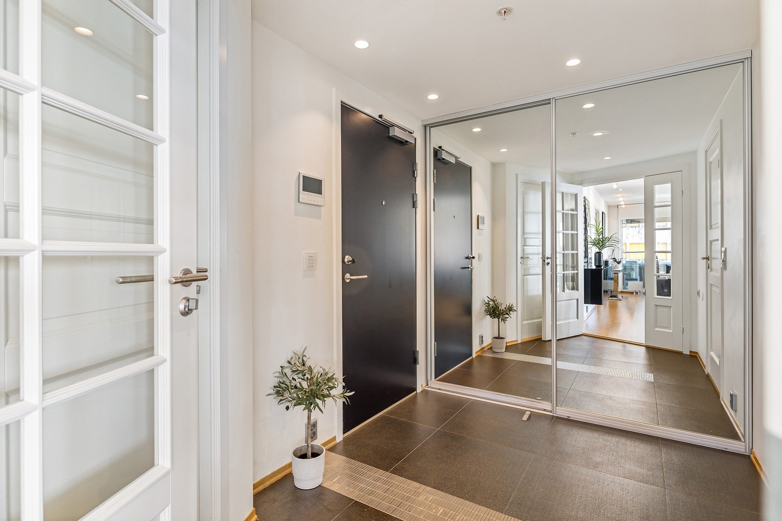 Stor skyvedørsgarderobe med speilfronter. Lekkert flislagt gulv. Galleribilde