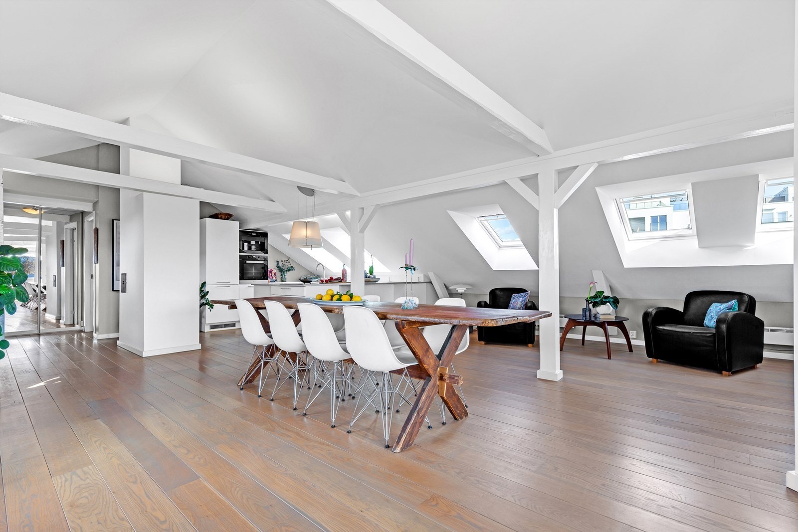 Takbjelkene får frem leilighetens gode takhøyde og sjarm, og de store vinduene slipper inn godt med naturlig lys til rommet, noe som igjen er med på å skape den gode atmosfæren. Galleribilde