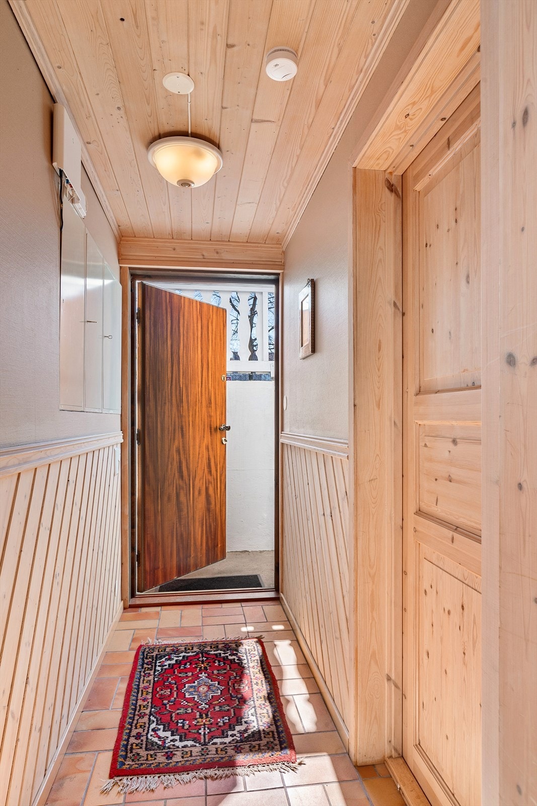 Kjellergang med dør ut til utvendig kjellertrapp Galleribilde