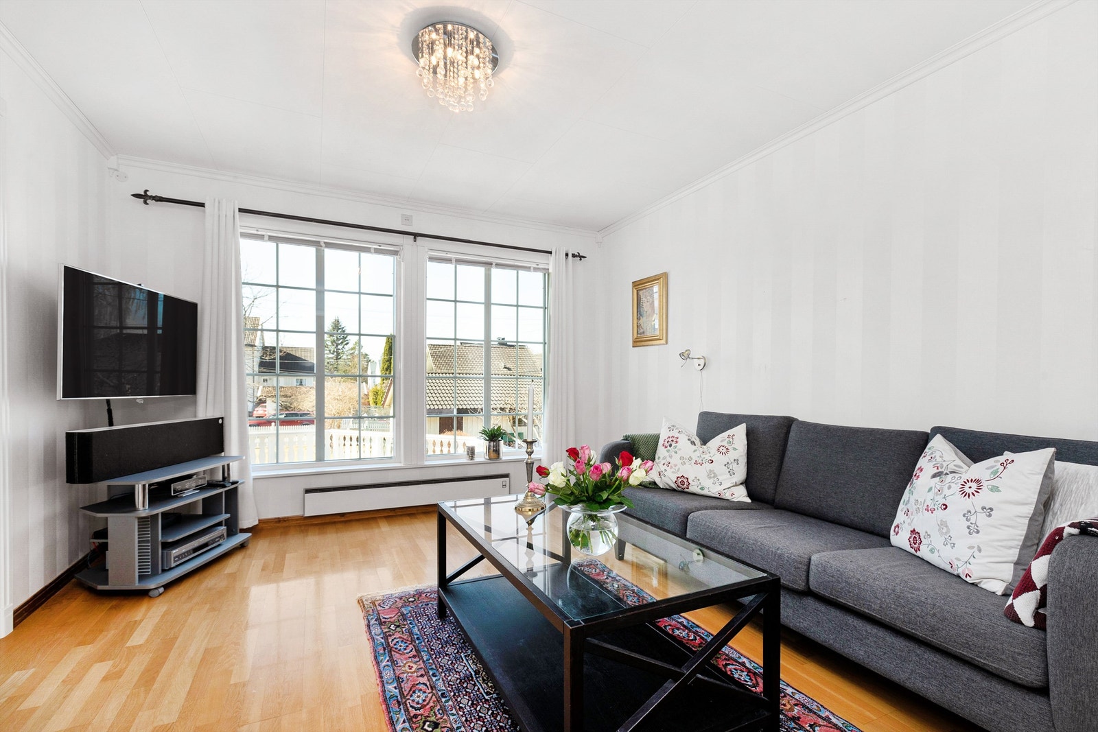 Fin og skjermet tv-stue med vinduer ut mot hagen Galleribilde