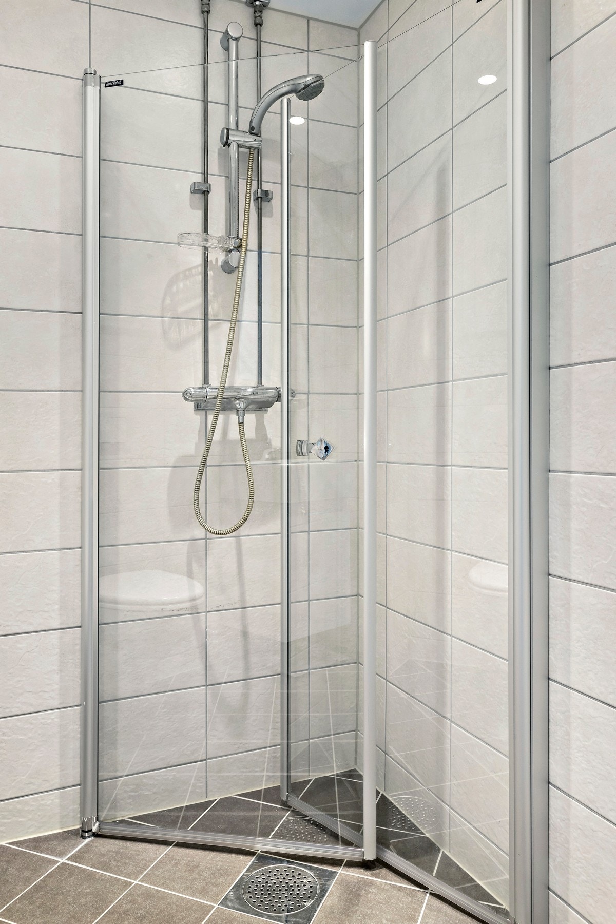 Innredningen består av dusjsone med innfellbare dører av herdet glass, vegghengt WC, servant med underskap og speilskap Galleribilde