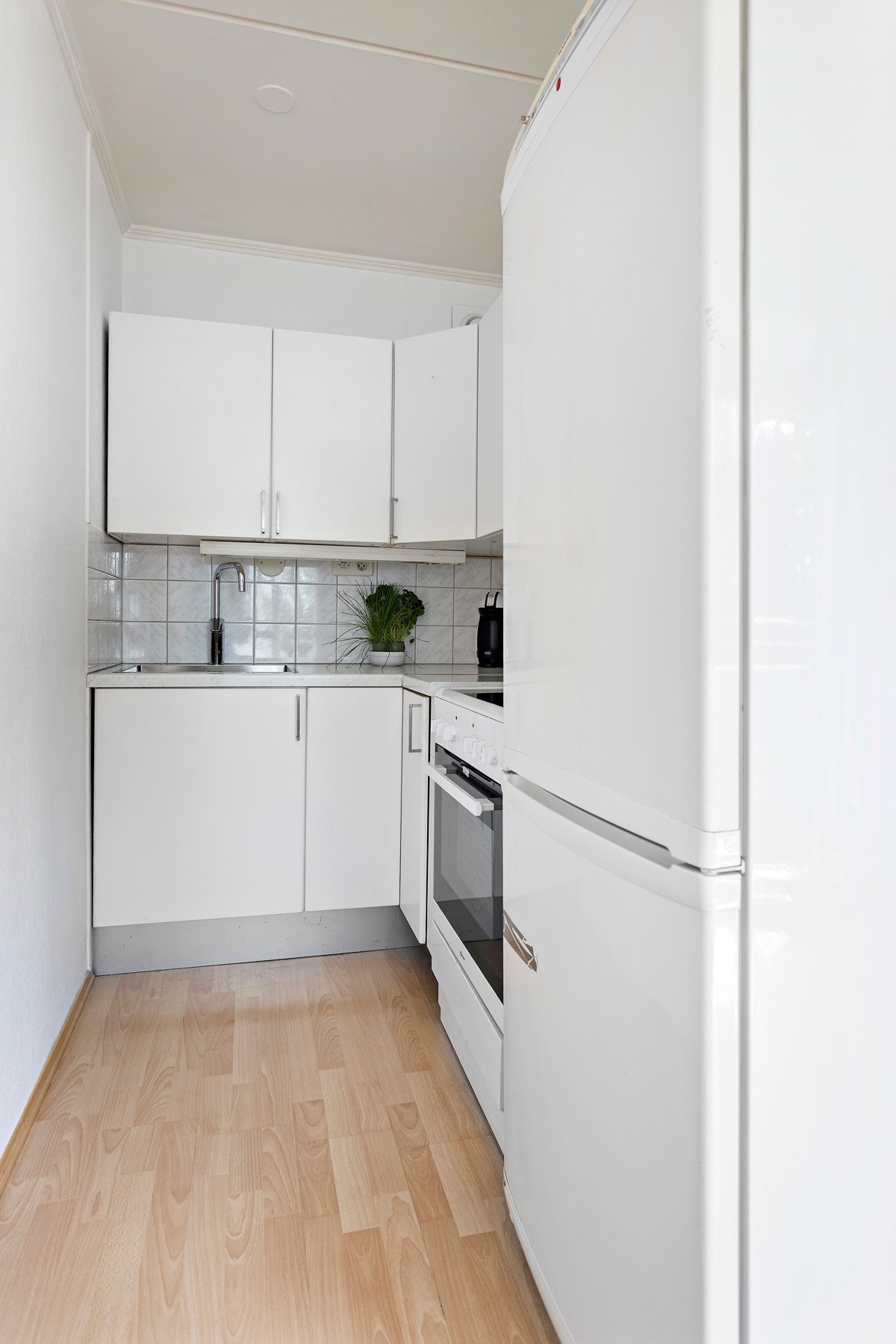 Praktisk kjøkkeninnredning som byr på god skap- og benkeplass Galleribilde