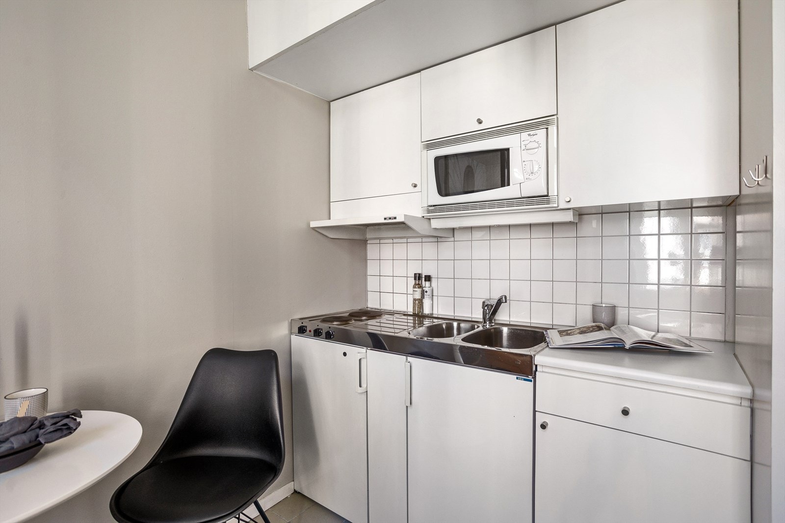 Integrerte hvitevarer, nedfelt koketopp i benkebeslag og kjøleskap, samt ventilator i overskap tilkoblet avtrekk Galleribilde