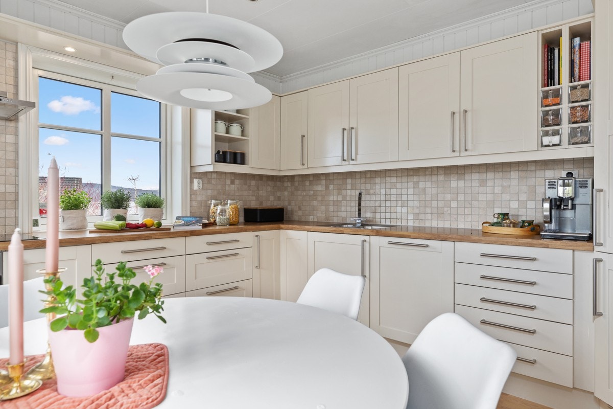 Kjøkkenet er i klassisk stil, med kremhvite profilfronter og kledelige fliser. AEG induksjonstopp 80 cm og AEG stekeovn nytt i 2019. Galleribilde