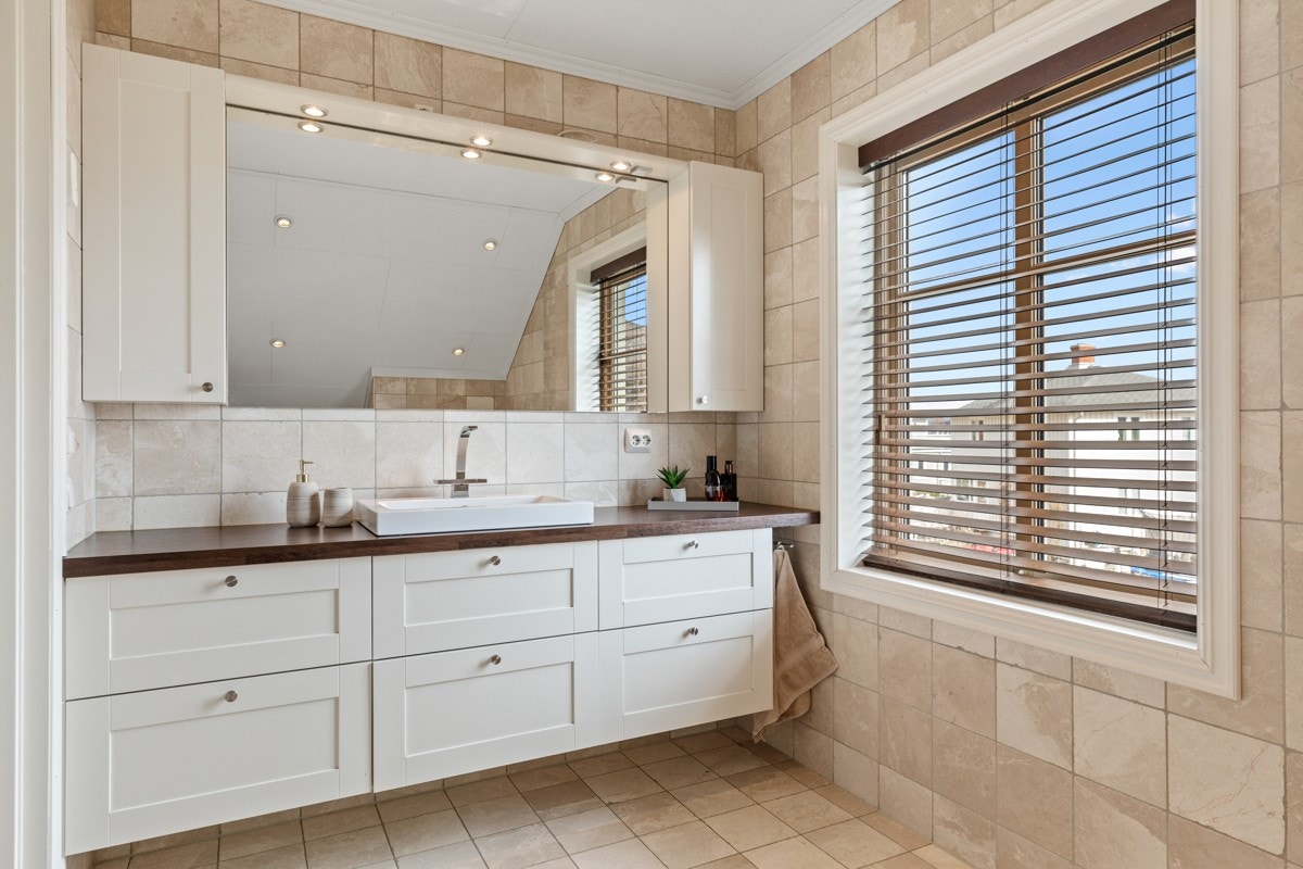 Boligen har et bad i hver etasje. Badet i andre etasje har sandfargede marmorfliser, gulvvarme og downlights Galleribilde