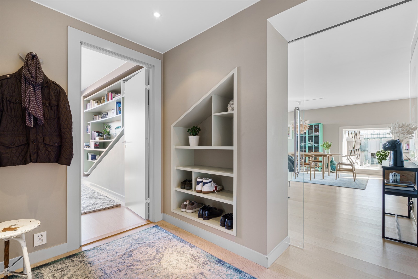 Fra entréen tar du deg videre inn ti leiligheten via en skyvedører i glass. Galleribilde