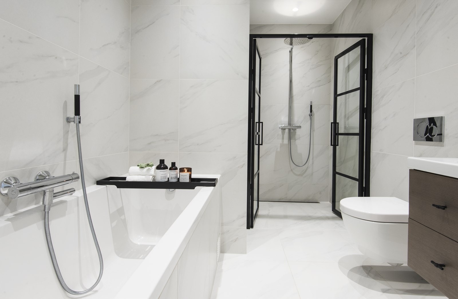 Baderom fra 2019 med dusjhjørne m/ Tapwell blandebatteri og håndlagde innfellbare dører og flislagt Duravitbadekar. Galleribilde