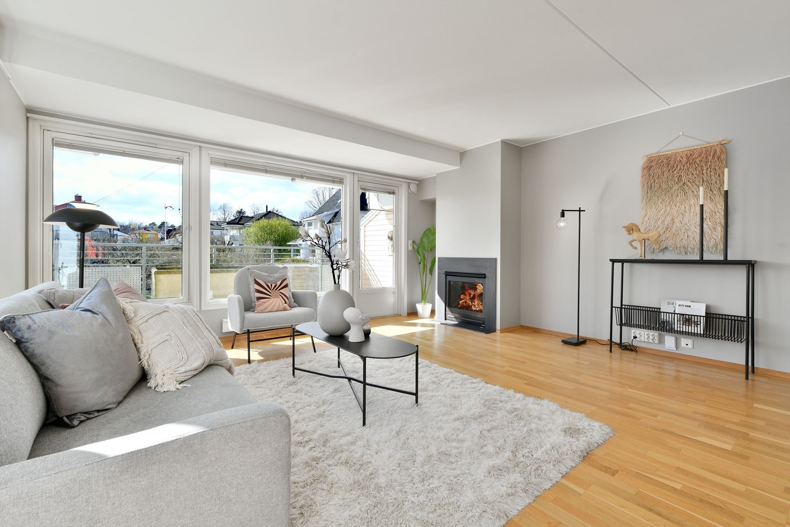 I enden av rommet er det utgang til balkong, og ved døren er det en gasspeis som bidrar med ekstra varme og hygge gjennom kalde årstider. Galleribilde