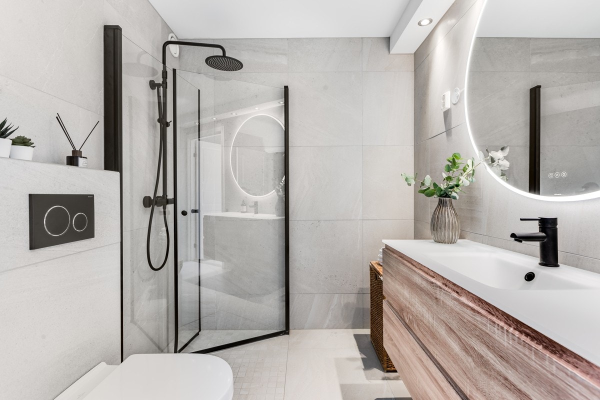 Et baderom som gir spa-følelsen hjemme. Opplegg til vaskemaskin ved siden av innredningen ovenfor dusjhjørnet. Galleribilde