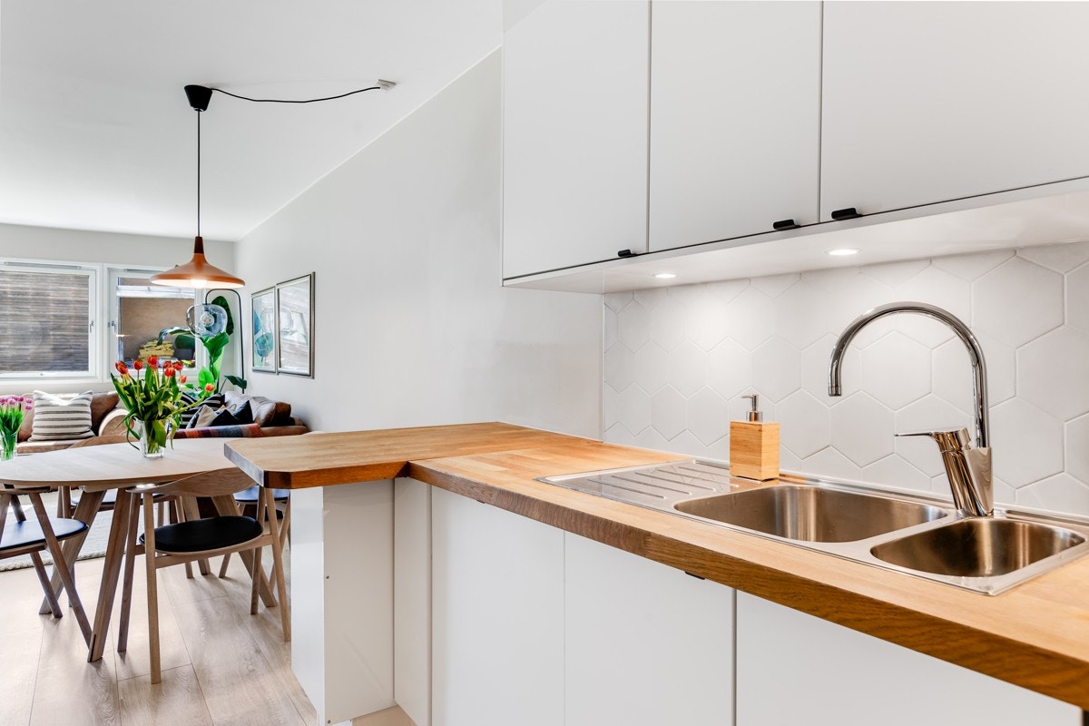 Heltre benkeplate og hvit innredning. Komplett utstyrt med integrerte hvitevarer. Galleribilde