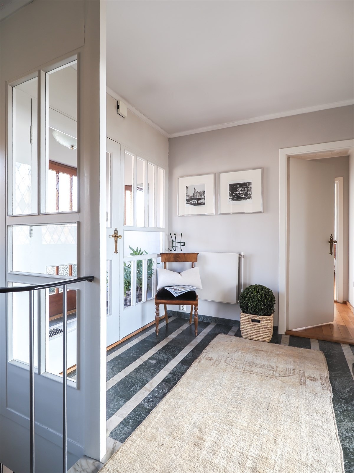 Romslig hall med marmorgulv og trapp ned til etasjen under. Galleribilde