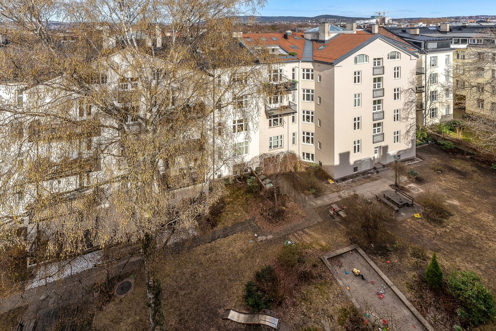 Felles bakgård opparbeidet med blant annet gressplen, prydbusker, diverse beplantning, sittegruppe og lekeapparater Galleribilde