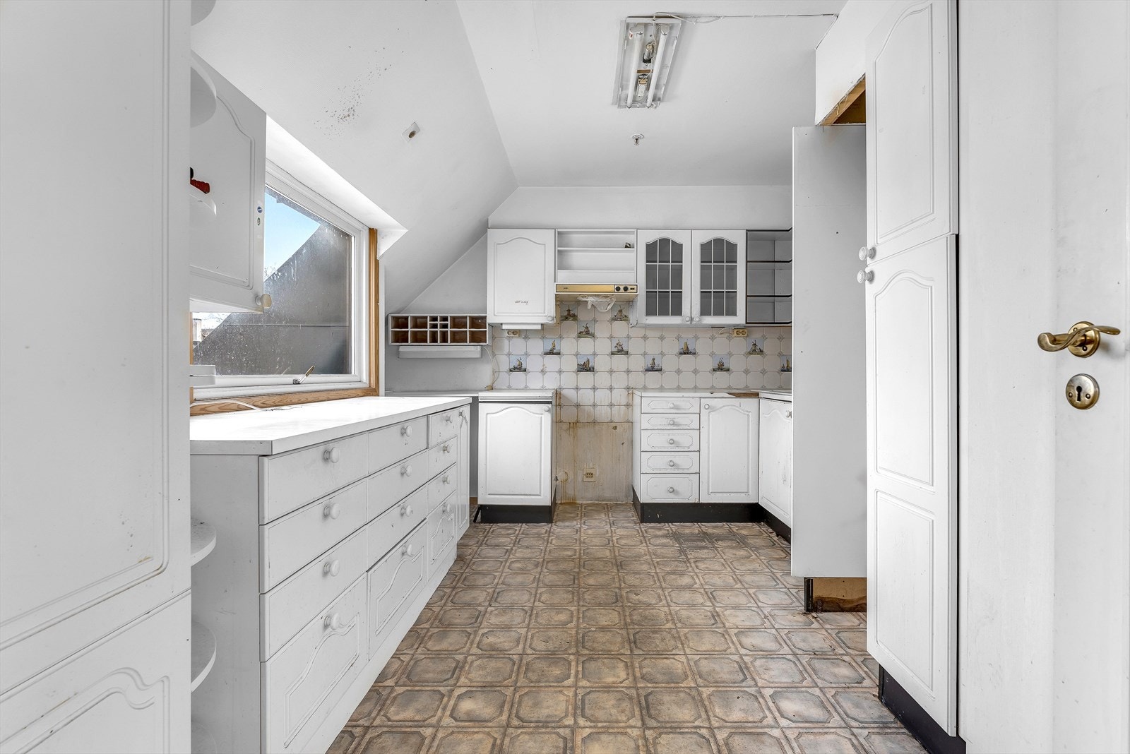 Eldre kjøkkeninnredning med omfattende slitasje Galleribilde