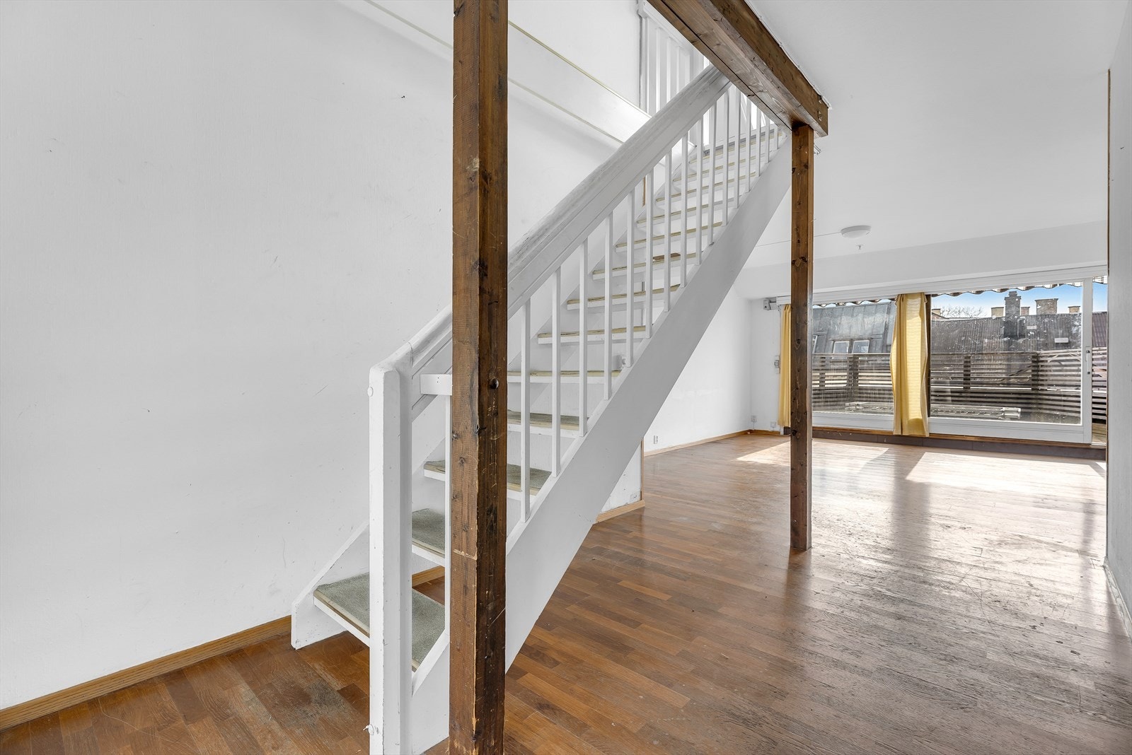 Gjennomgående leilighet og store skyvedører til terrasser gir rikelig med naturlig lys. Trapp fra stuen til leilighetens andre plan Galleribilde