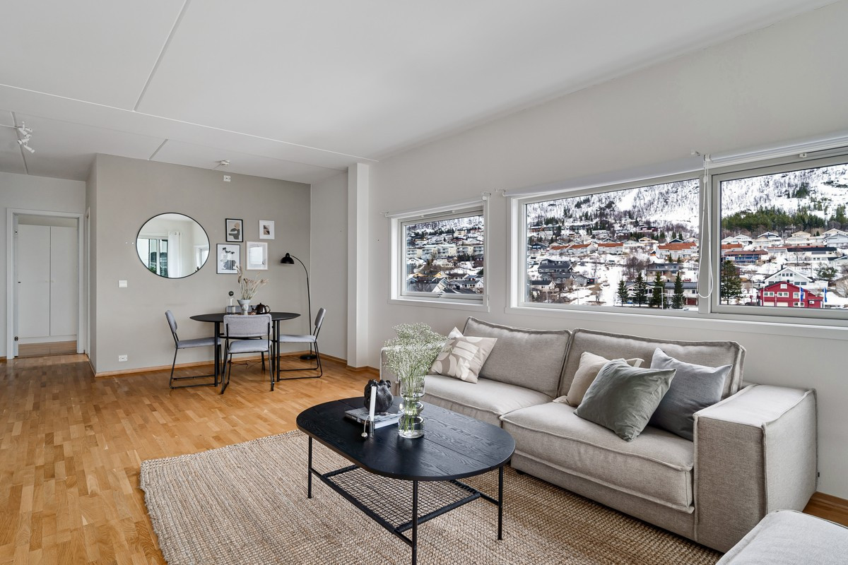 Lysmalt stue med store vindusflater som slipper inn rikelig med naturlig lys