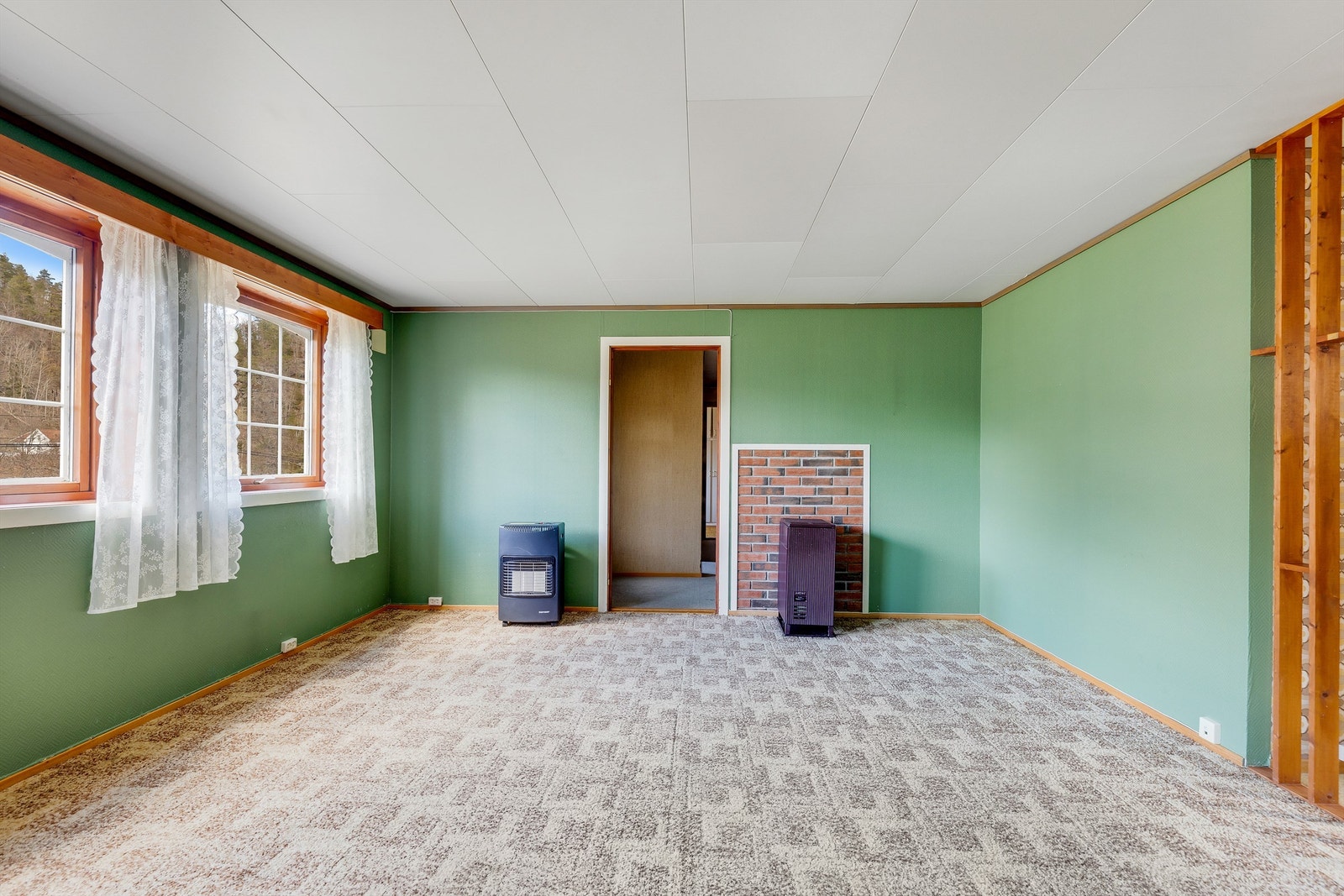 Stuen har store vinduer som slipper inn mye sollys. Galleribilde