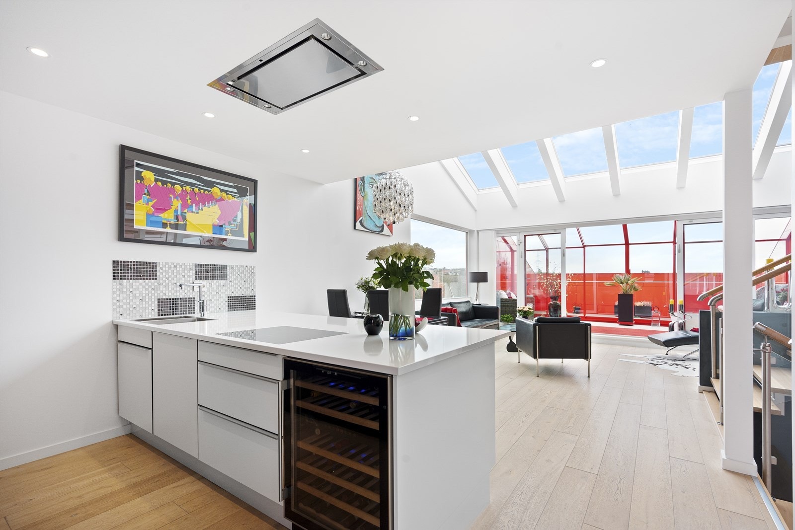 Kjøkkenøy har heldekkende hvit granittplate og vinskap Galleribilde