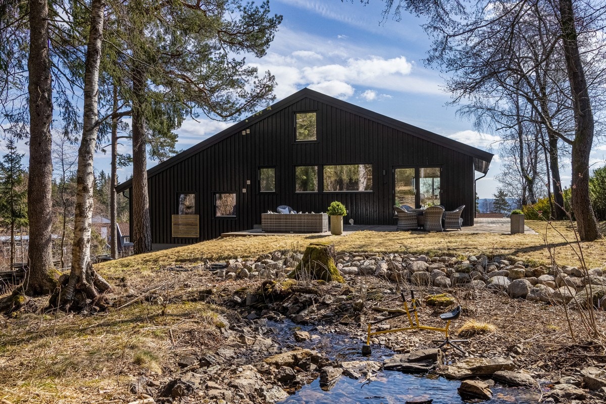 Idylliske Risbekken renner ut fra Båntjern og avgrenser eiendommen mot marka. Galleribilde