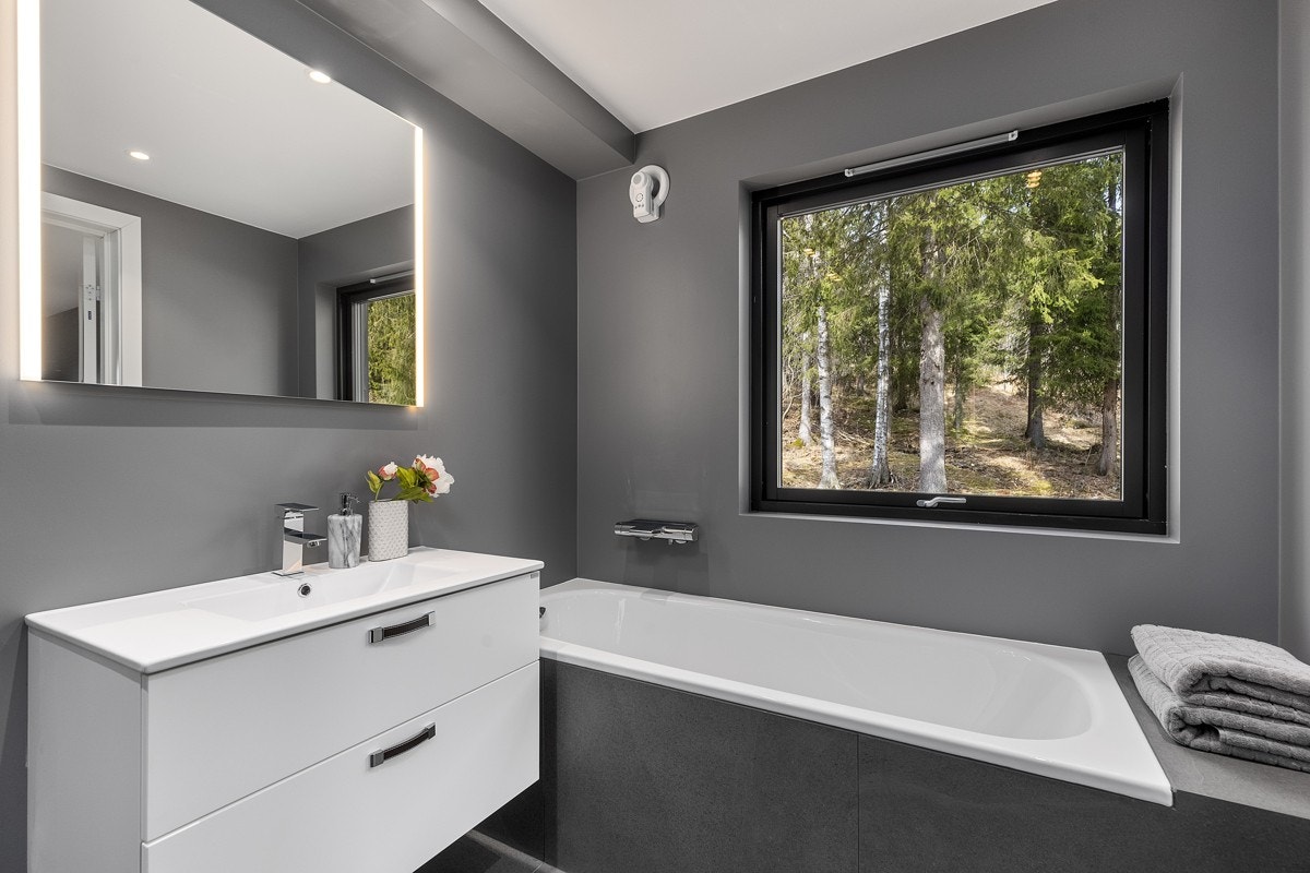 Bad 2 ( med adkomst fra hovedsoverom ) - Veggmontert wc, hvit høyglanset innredning med to skuffer og heldekkende servant, veggmontert dusj og hodedusj i nisje med to vendbare dører, innmurt flislagt badekar med dusj, fordelingsskap og overløpsventil. Galleribilde