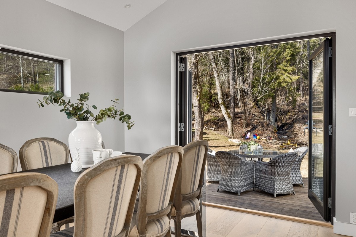 Utgang fra spisestuen til stor terrasseplatting, hagen og videre ut i marka. Galleribilde