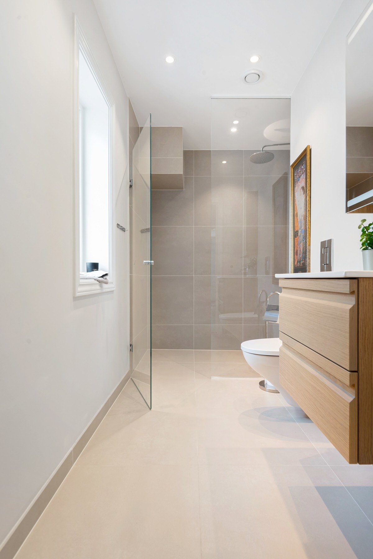 Dusjsonen er skjermet av glassvegg med tilhørende glassdør, og er ellers utstyrt med rainshower og hånddusj tilknyttet Tapwell blandebatteri og avlangt sluk av typen Purus Line. Videre har badet gulvvarme, velplasserte led-downlights og vegghengt toalett. Galleribilde