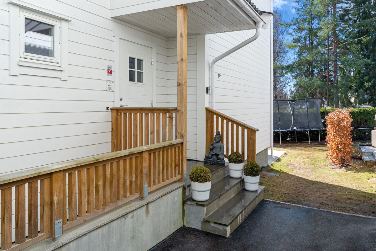 Boligen har et lunt inngangsparti med overbygg, rekkverk og støpt trapp med repos. Galleribilde