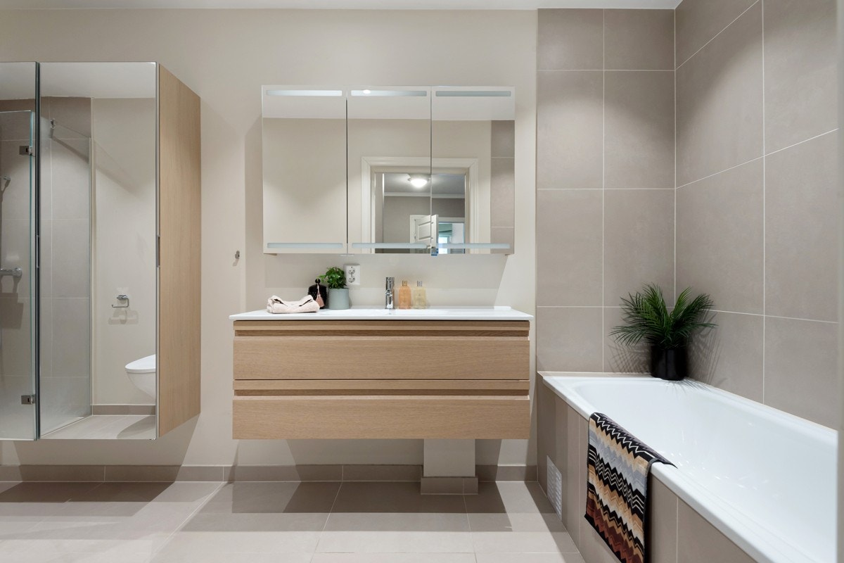 Det største badet er innredet med vegghengt toalett, dusjhjørne med regnfallsdusj bak glassdører og et innfliset badekar. Galleribilde