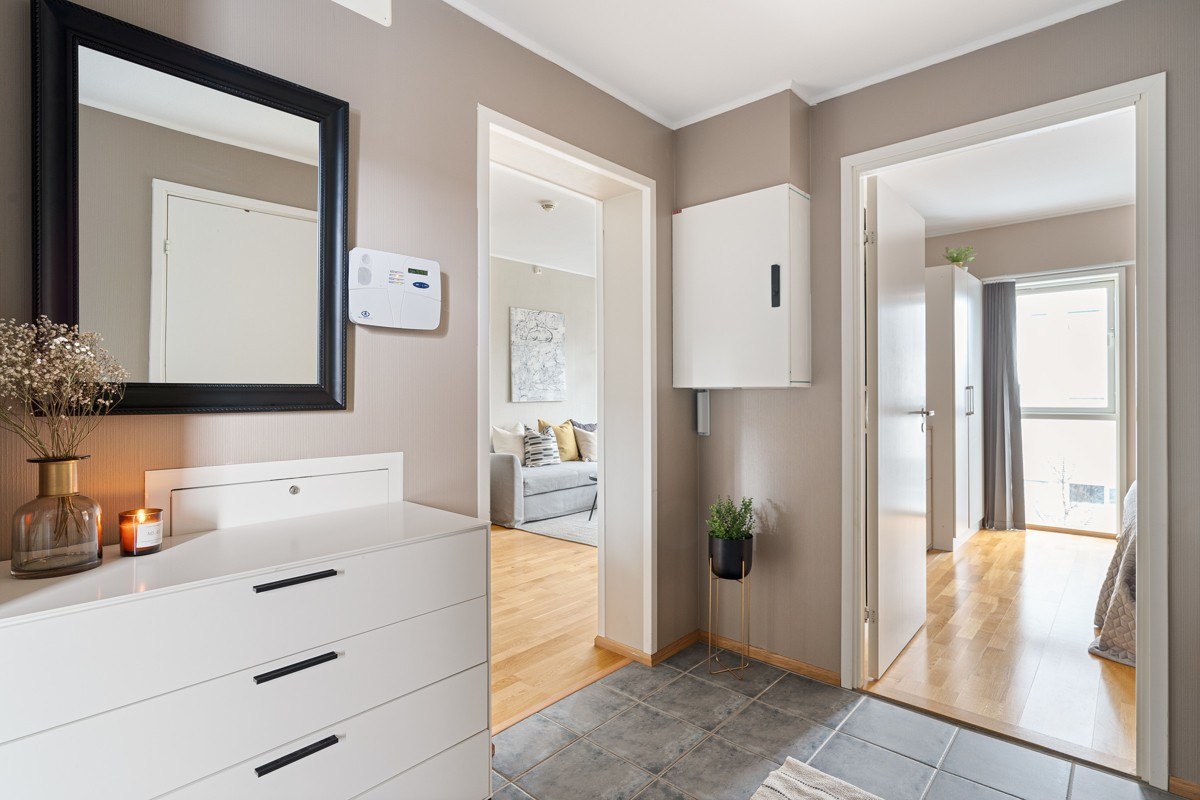 Velkommen inn! Leiligheten har en romslig og innbydende entré med varmekabler i gulv