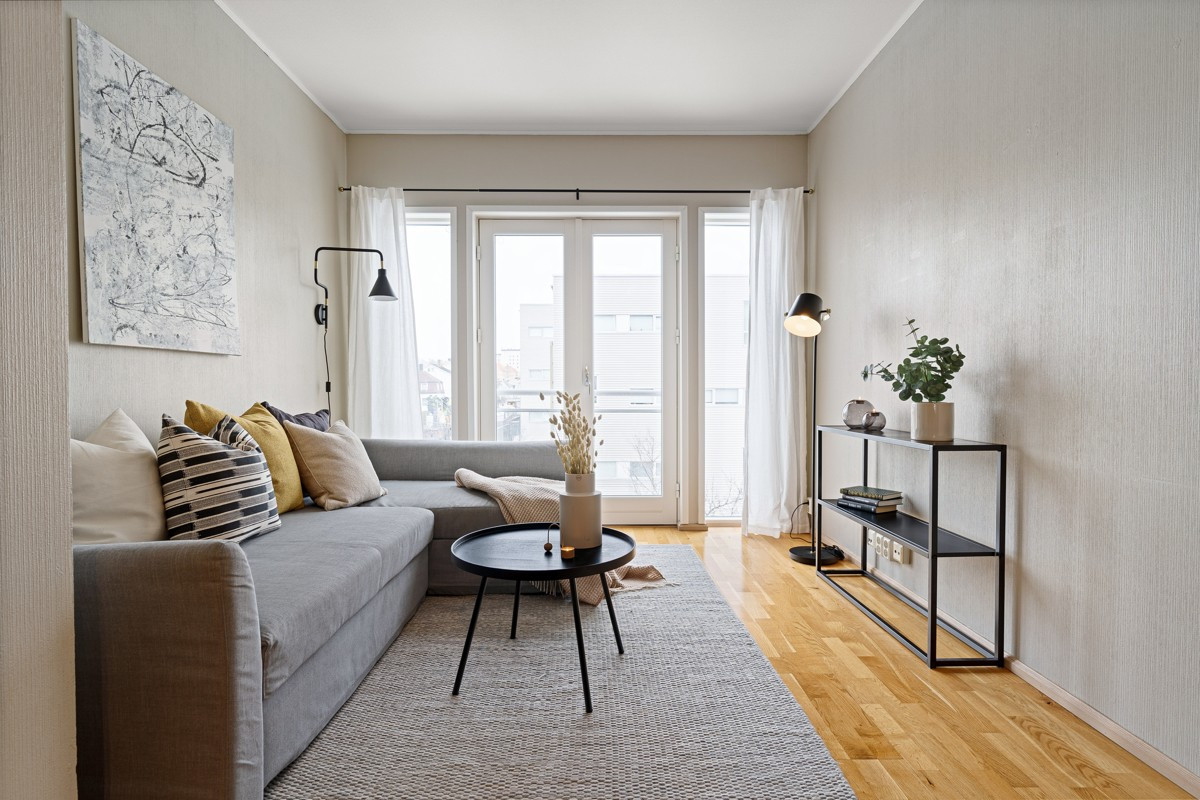 Stor stue med store vindusflater som slipper inn rikelig med naturlig lys. Her er det også verandadør mot fransk balkong