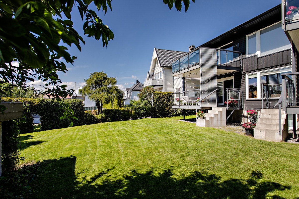 Fasade - Pent opparbeidet hage med gressplen og beplantning Galleribilde