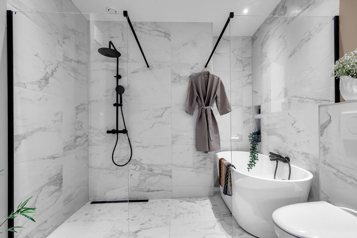 Baderomsinnredningen består av dusjnisje med regn- og hånddusj, frittstående badekar, dobbelservant med underskuffer og vegghengt toalett. Opplegg for vaskemaskin Galleribilde