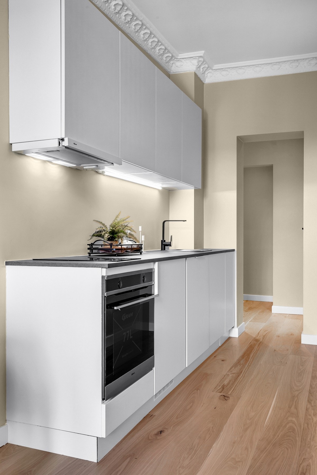 Kvik Senti kjøkkeninnredning, laminat benkeplate, utslagsvask med ettgreps blandebatteri og kullfilter. Integrerte hvitevarer som komfyr, induksjonstopp, oppvaskmaskin og benkekjøleskap som medfølger Galleribilde