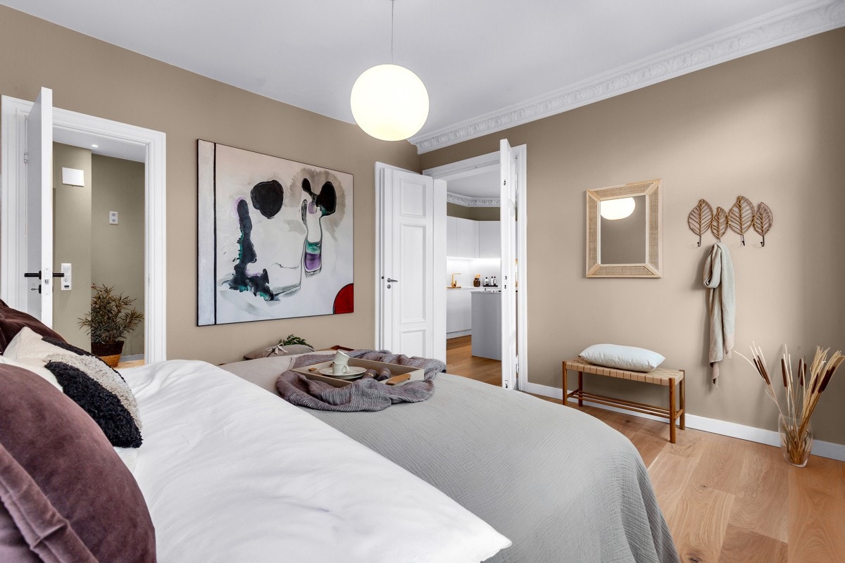 Énstavs eikeparkett, malte overflater og klassiske detaljer som rosett, stukatur, to-fløyede dører, store vinduer og dype karmer. Fra soverommet er det inngang til boligens baderom Galleribilde