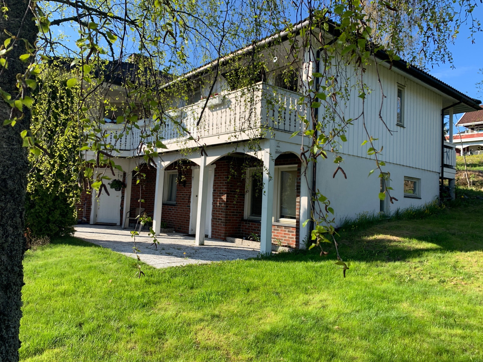 Hellelagt inngangsparti med plen foran Galleribilde