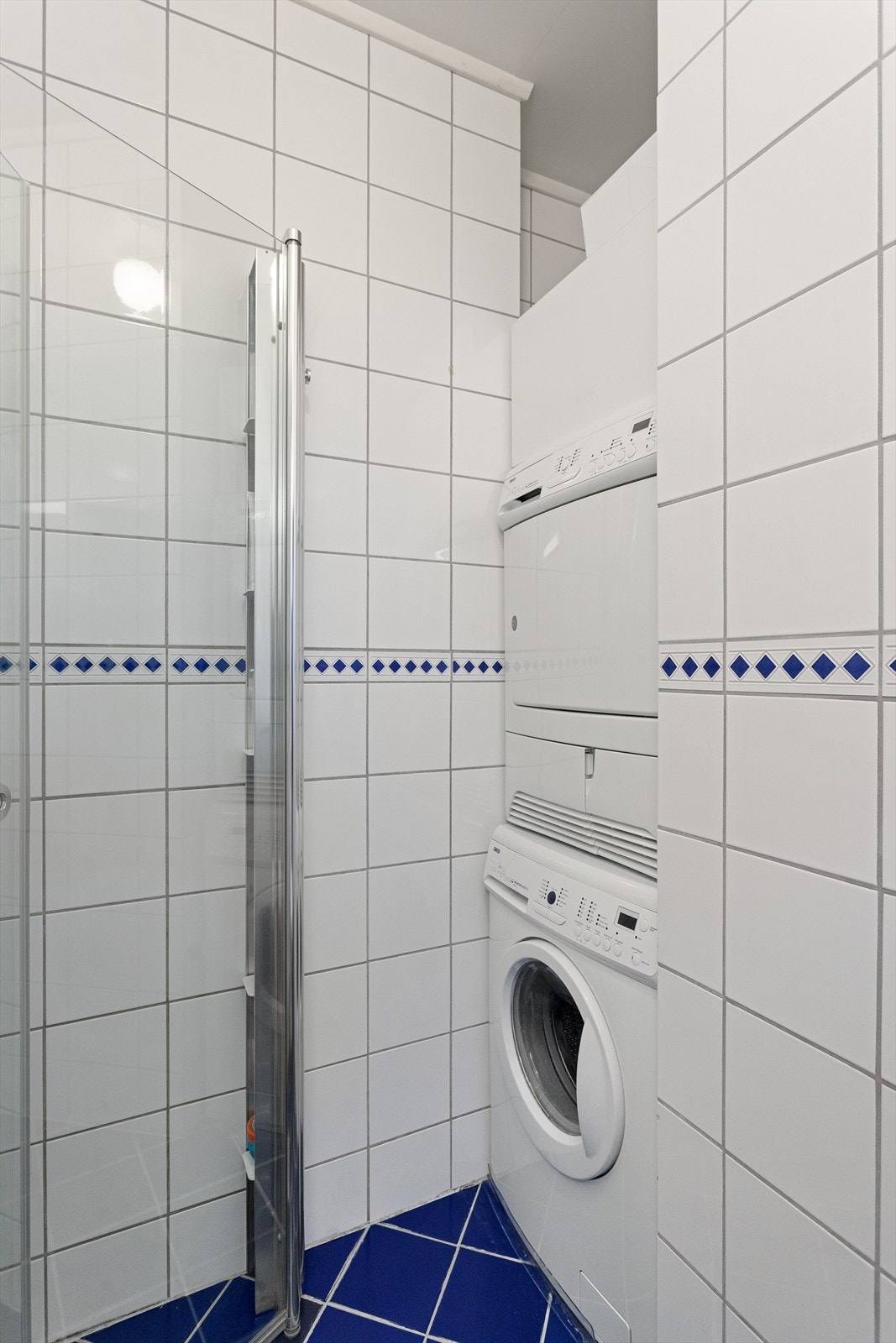 Badet er praktisk innredet med en liten krok/nisje for vaskemaskin og tørketrommel. Galleribilde