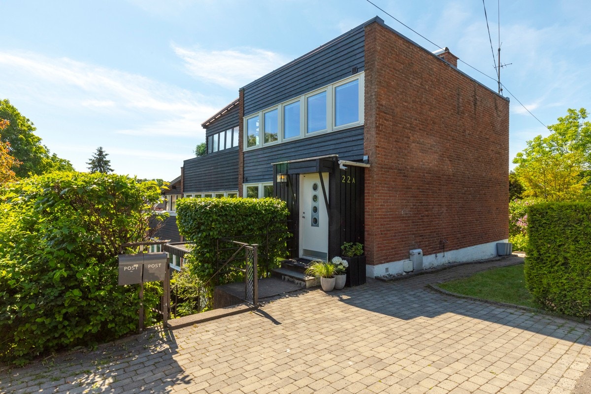 Enebolig i rekke over tre plan med praktikantdel og garasje. El-bil lader montert på husvegg etter at bilde ble tatt. Galleribilde