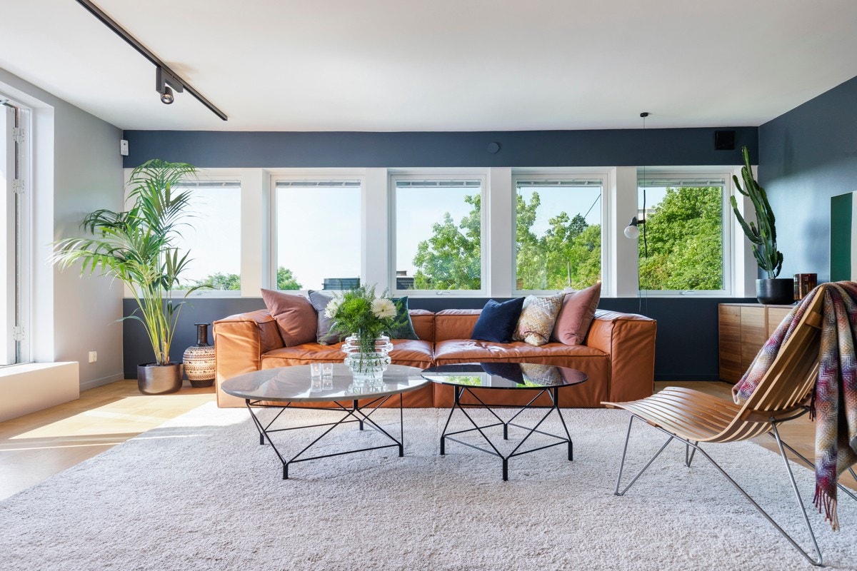 Sydvestvendt stue med store vindusflater som gir godt med naturlig lys. Måltilpassede persienner på vinduer og dører. Galleribilde