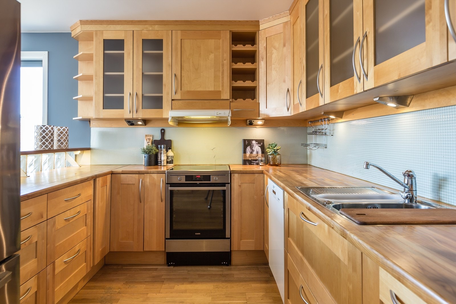 Kvalitetskjøkken fra Nova med slette bjørkefronter, heltre benkeplate og nedfelt kum med avfallskvern. (https://www.nova-group.no/) Galleribilde