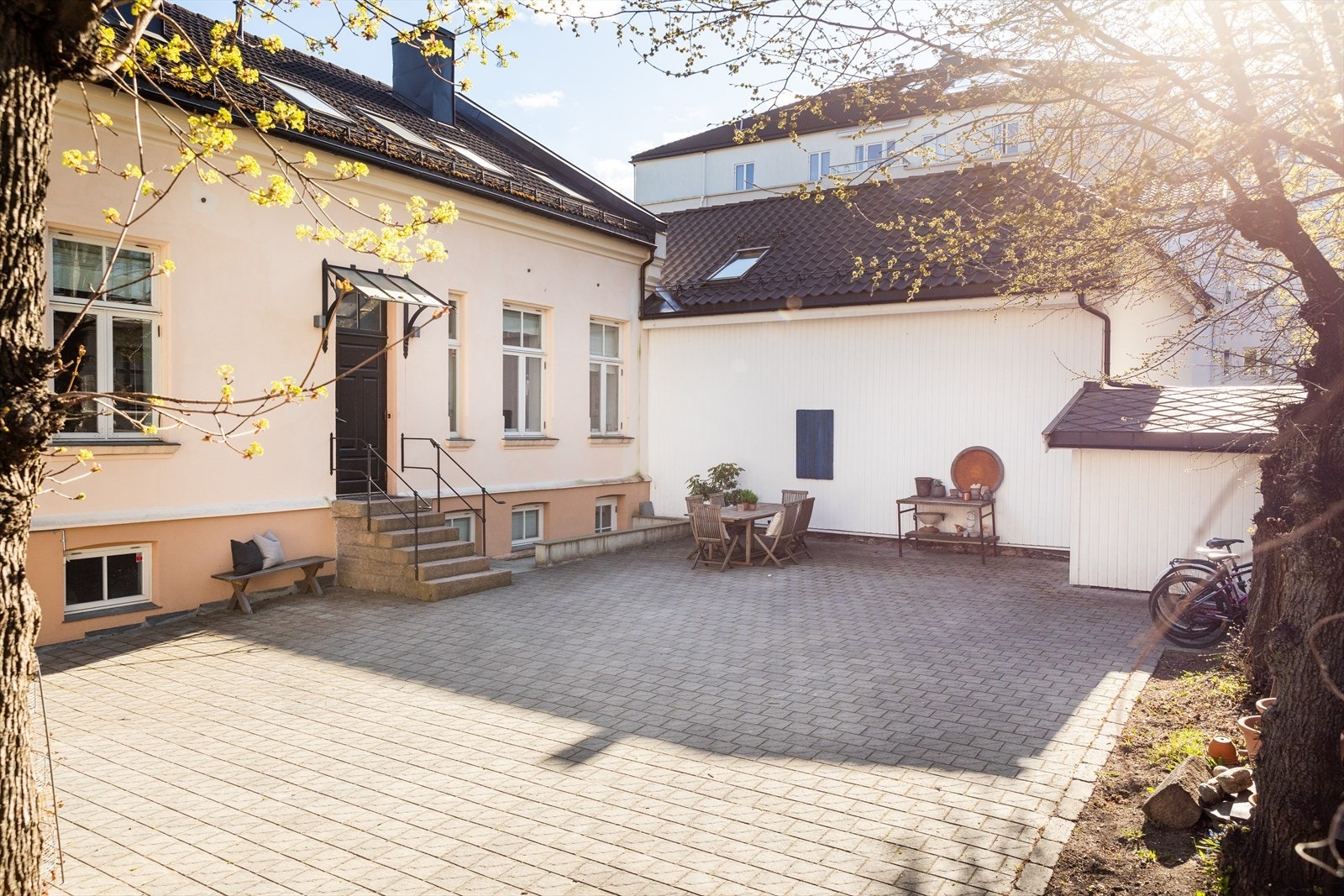 På gårdsplasse er det god plass til både parkering og sittegruppe. Galleribilde