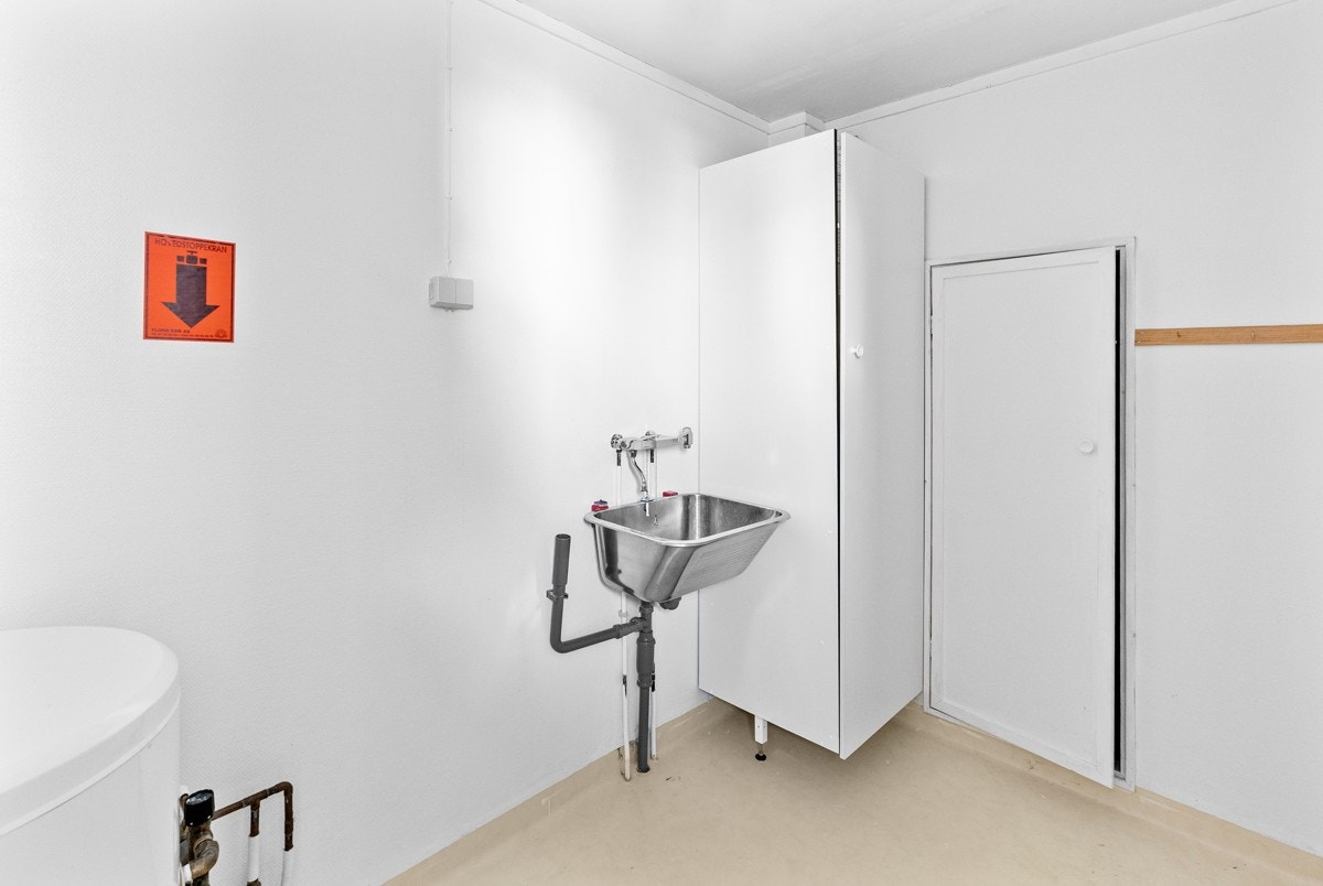 Ved siden av vindfanget finner en boligens vaskerom. Rommet er innredet med 120 liters varmtvannsbereder, vegghengt stålvask og høyskap. Galleribilde