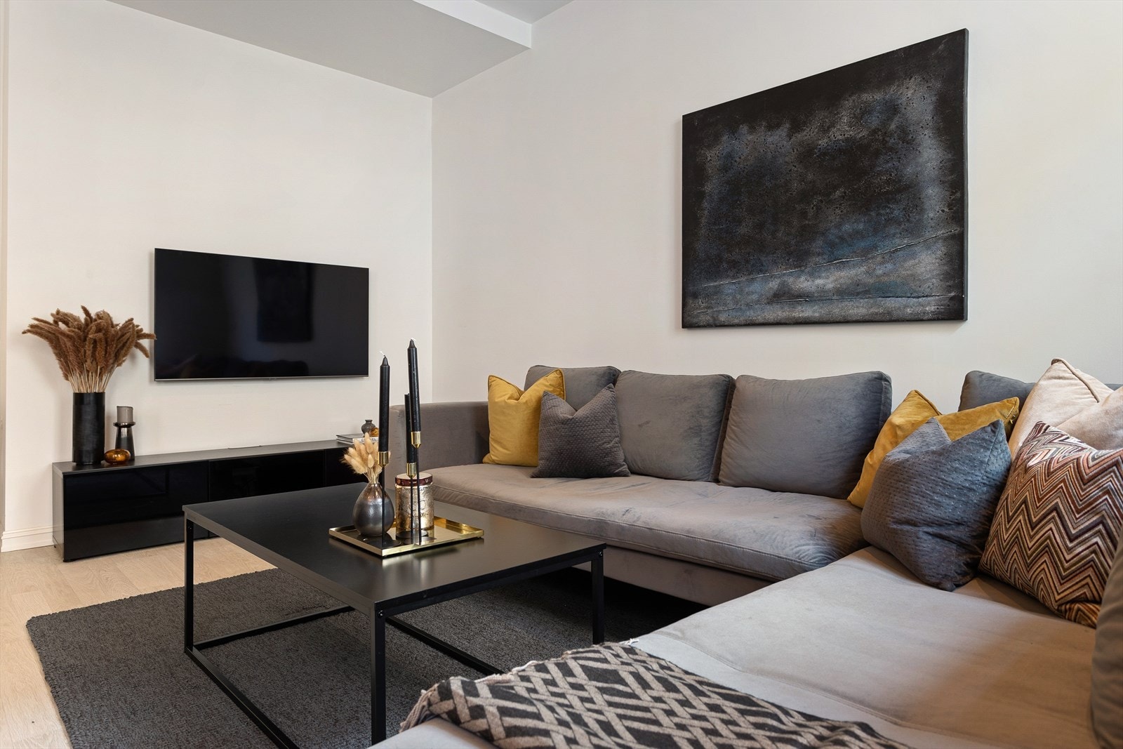 Romslig stue med god plass til sofaseksjon med tilhørende møblement og underholdningsavdeling Galleribilde