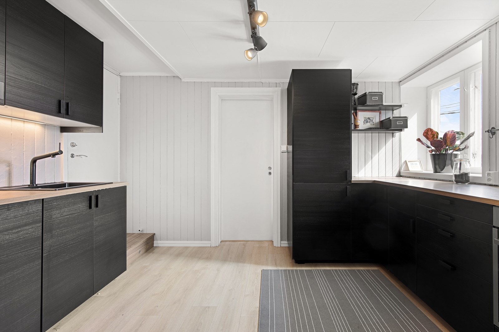 Kjøkkenet har godt med skap- og benkeplass Galleribilde