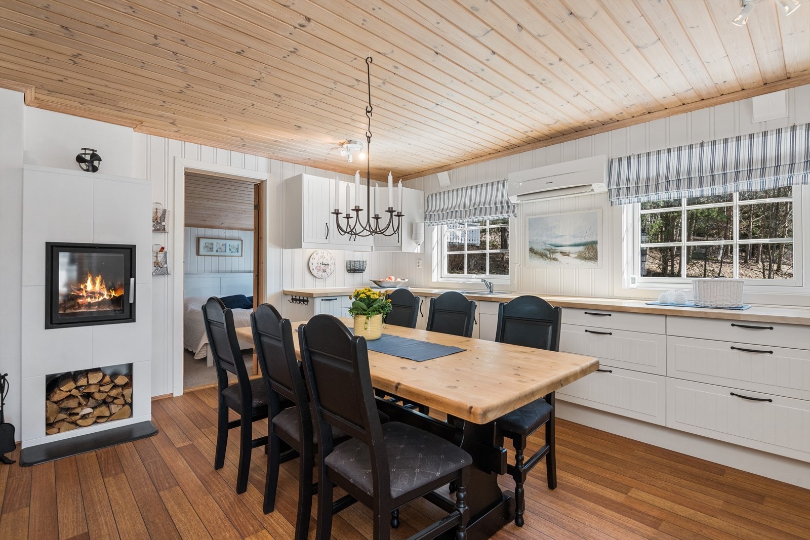 Kjøkkenet er romslig, med en tidløs innredning, varmepumpe og peis. Her har du også god plass til et stort spisebord Galleribilde