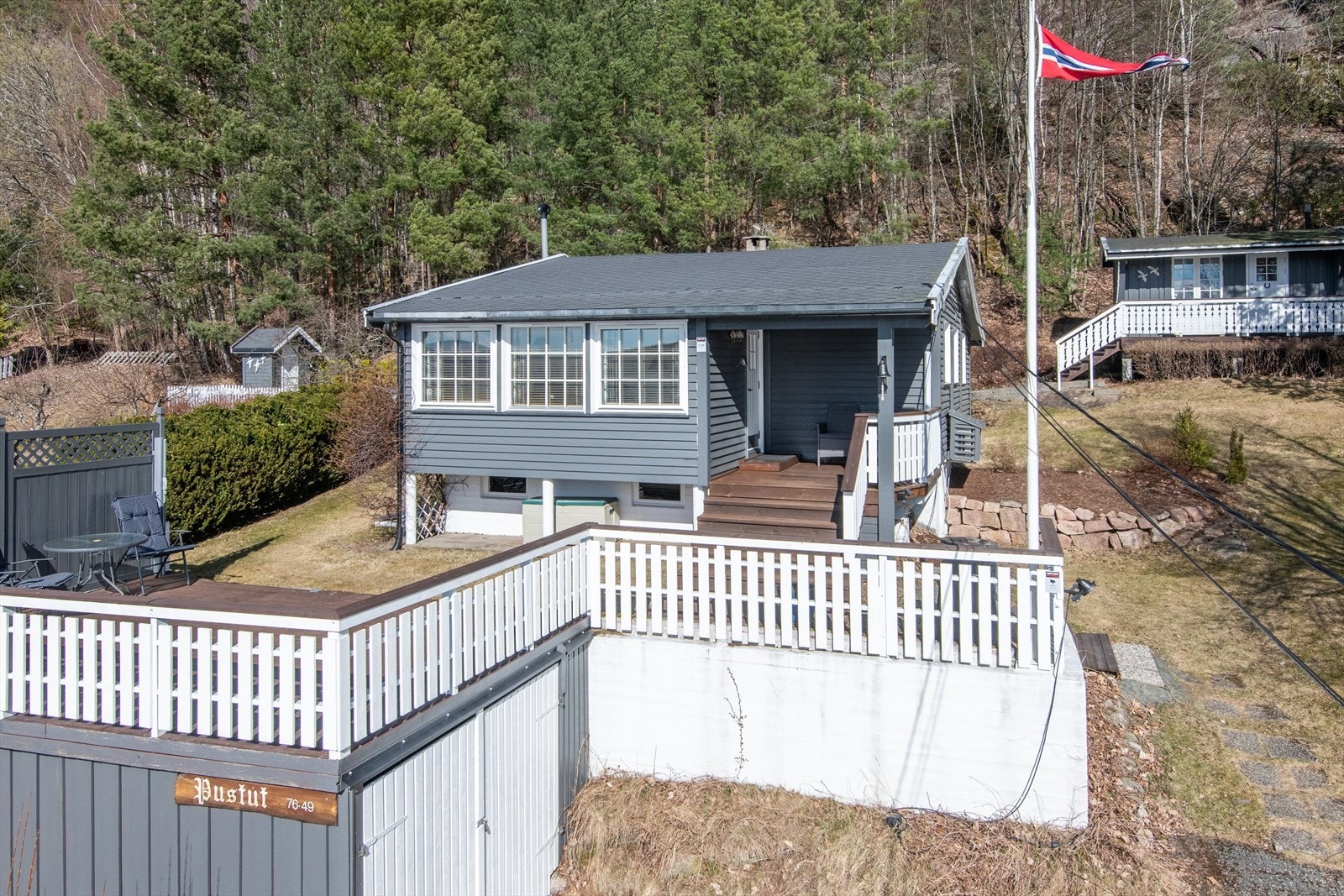 Tomten er opparbeidet med hytte, anneks, flere uteplasser samt carport Galleribilde