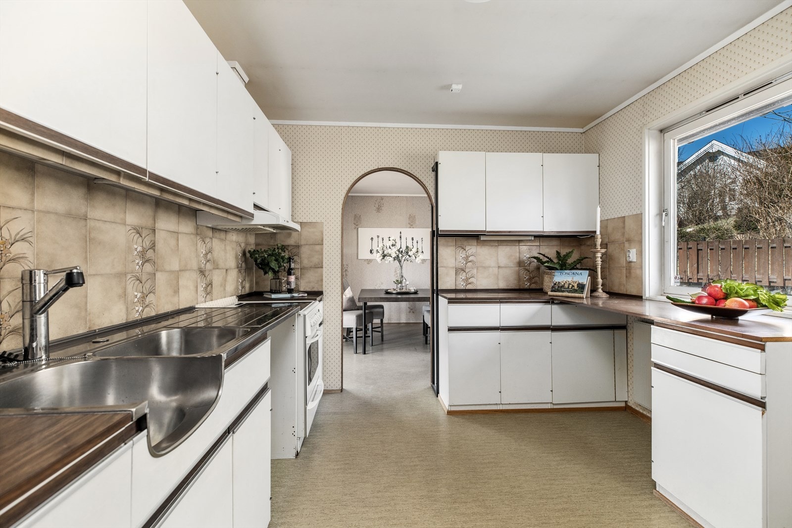 Kjøkkenet har god lagringsplass og gode arbeidsflater. Spisestuen er anlagt ved utgangen av kjøkkenet. Veggen mellom er satt opp med en tynn plate i ettertid og kan enkelt fjernes. Galleribilde