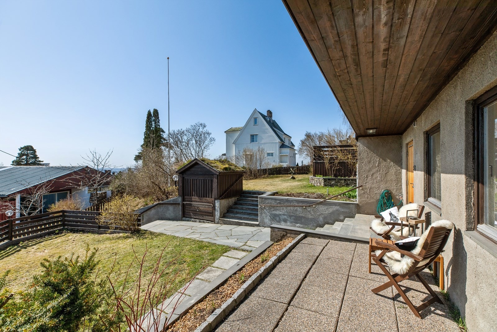 Eiendommen har flere lune og solfylte uteplasser, her sett fra adkomstsiden Galleribilde
