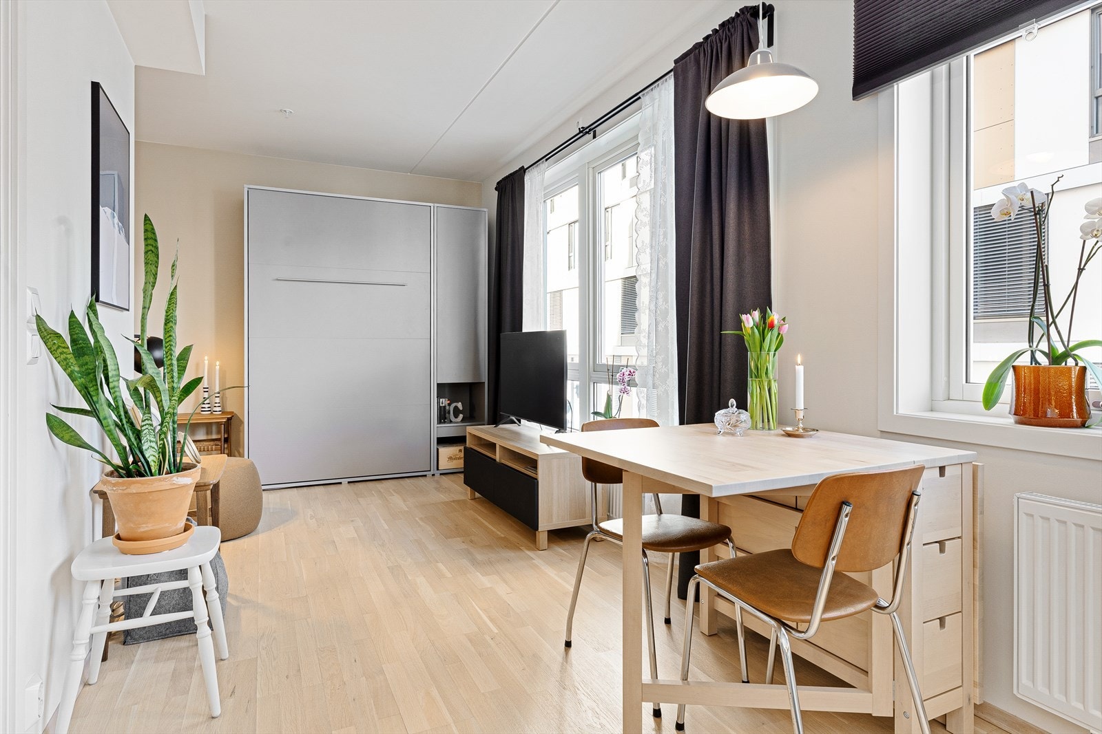 Mellom kjøkken og stue har man plass til et koselig frokostbord ved vinduet. Galleribilde