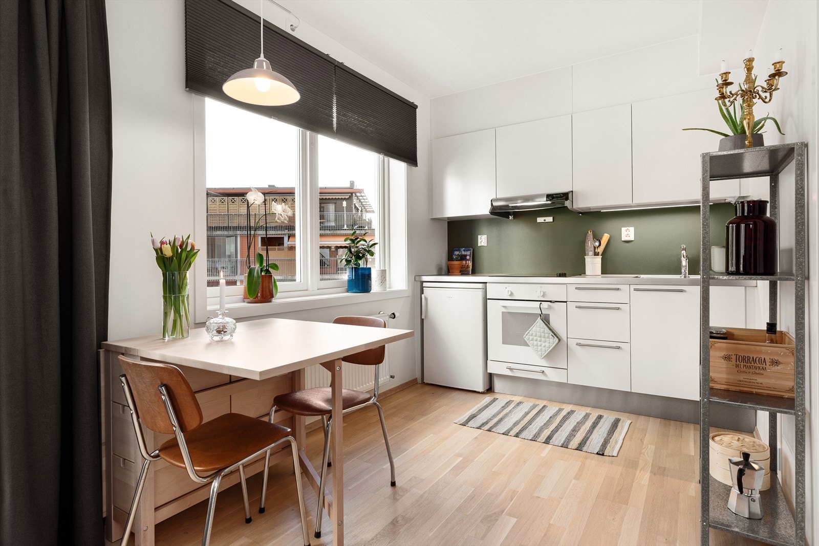 Innredningen har hvite glatte fronter, takhøye overskap og laminat benkeplate. Galleribilde