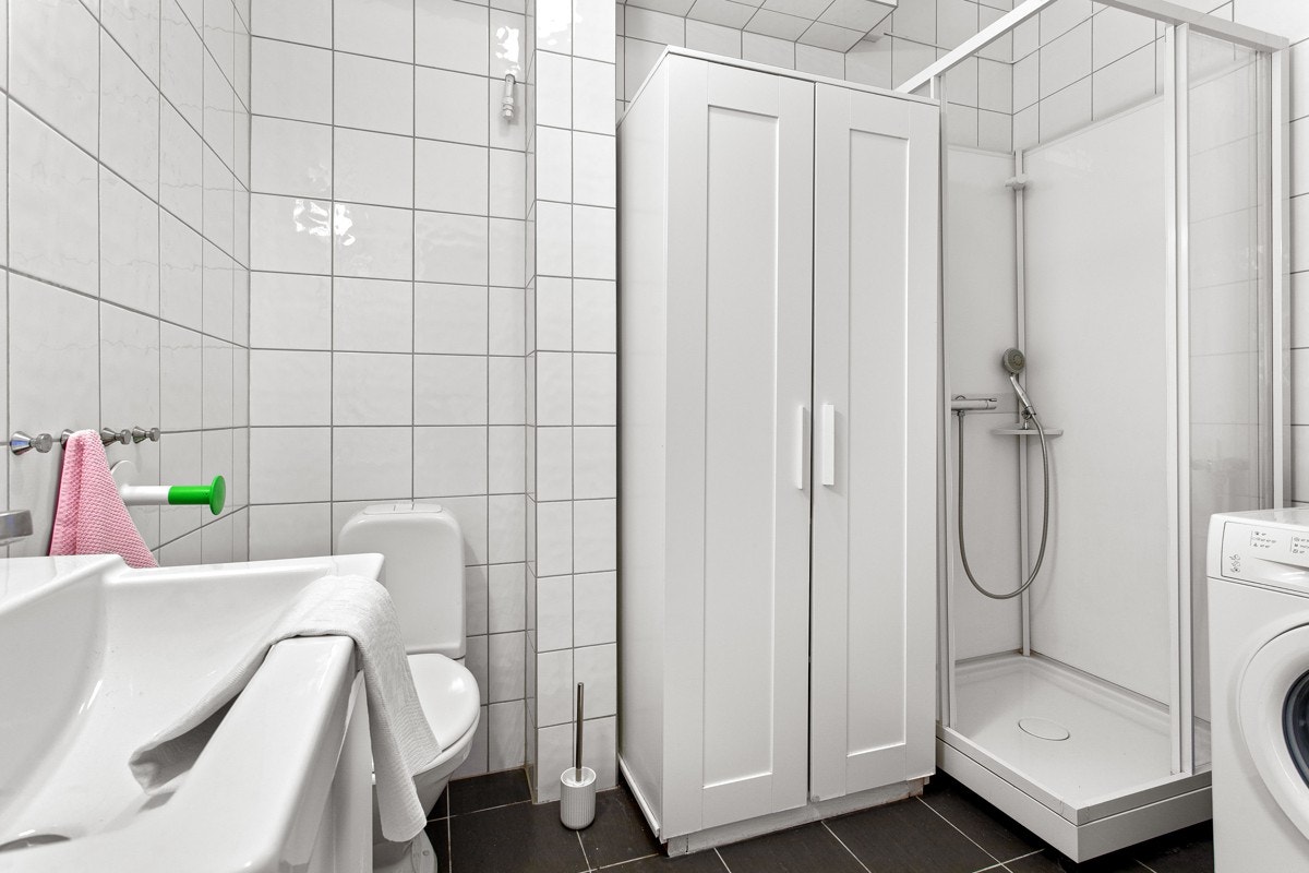 Det er hvite fliser på vegger og mørke fliser på gulv, samt behagelig gulvvarme. Galleribilde