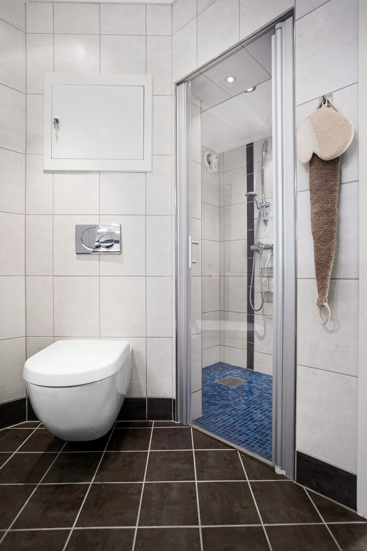 På badet er det vegghengt toalett og dusjhjørne